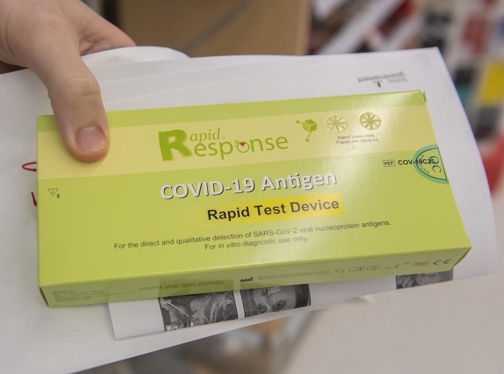 A man holds a box of COVID-19 rapid tests