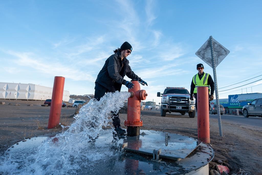 Members of the Iqaluit Fire Department in Nunavut assist with flushing the city's water pipes on Wednesday, Oct. 27, 2021. THE CANADIAN PRESS/Dustin Patar.