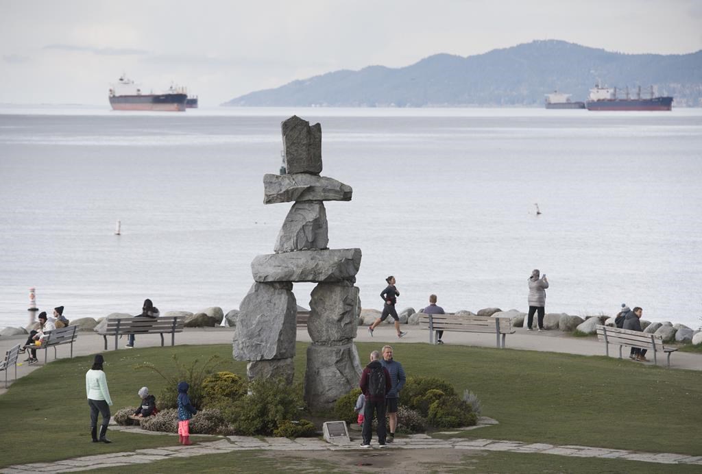 People attempt to physical distance themselves from one another as they walk along the seawall in Vancouver, Tuesday, March 31, 2020. Tourism operators in British Columbia can aply for help under a $15-million relief fund to cover some of their losses due to COVID-19. THE CANADIAN PRESS/Jonathan Hayward.