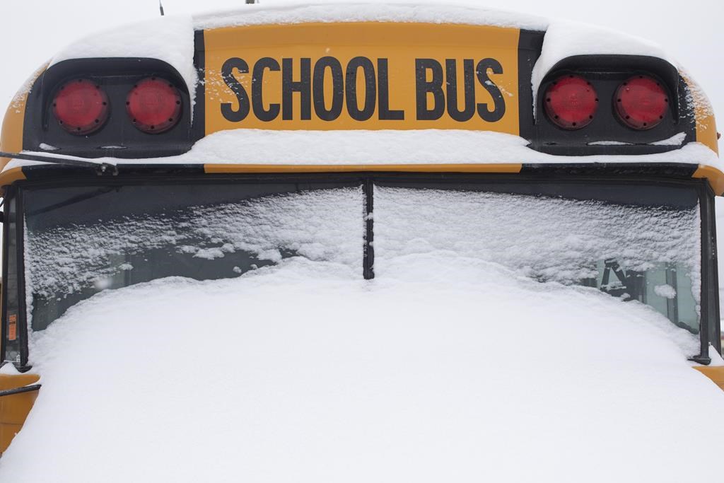 A school bus sits idle after winter conditions suspended the school transportation service in Toronto on Tuesday, Feb. 16, 2021.