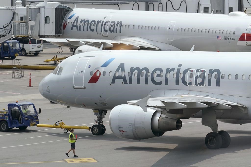 American Airlines passenger jets prepare for departure, Wednesday, July 21, 2021, near a terminal at Boston Logan International Airport, in Boston.