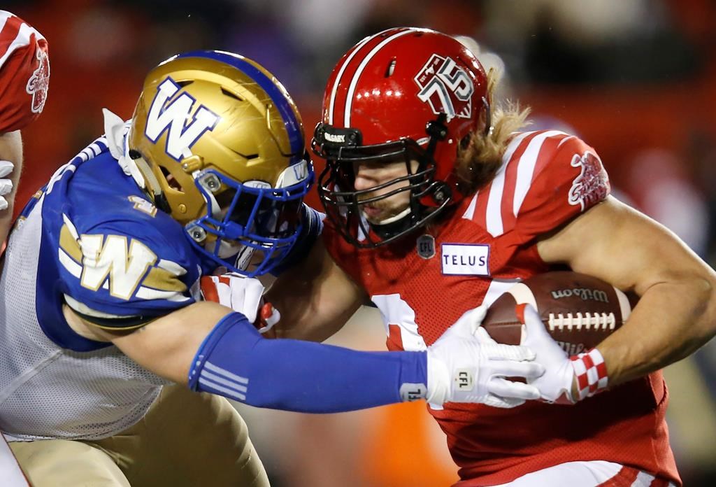 Winnipeg Blue Bombers’ Adam Bighill stops Calgary Stampeders’ Ante Milanovic-Litre during the second half of a CFL football game in Calgary.