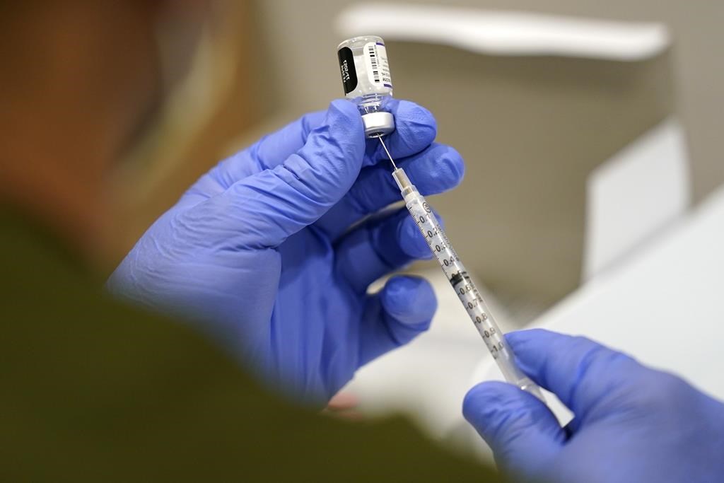 FILE - A healthcare worker fills a syringe with the Pfizer COVID-19 vaccine at Jackson Memorial Hospital on Oct. 5, 2021, in Miami. 