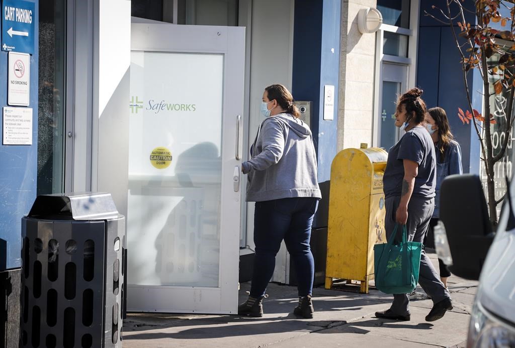 People wait to enter the Safeworks supervised consumption site at the Sheldon M. Chumir Health Centre in Calgary on Thursday, Aug. 26, 2021.