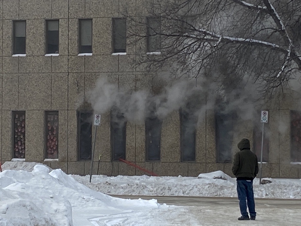 Smoke billows out of first floor windows from a fire at 717 Portage Avenue.