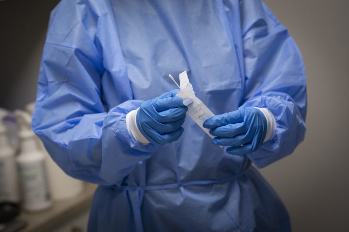 A pharmacist holds a COVID-19 test swab at a pharmacy in Amherstview, Ontario on Friday, January 22, 2021.