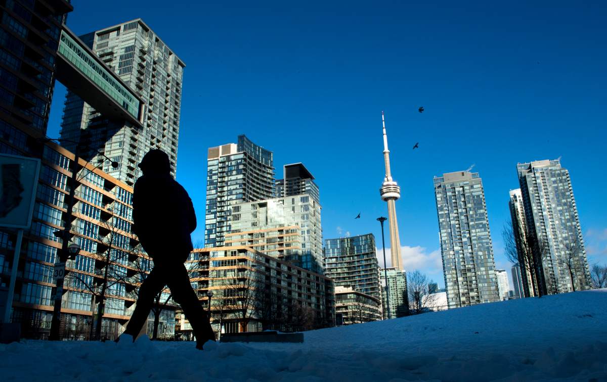 Condo towers dot the Toronto skyline as a pedestrian makes his way through the COVID-19 restricted winter landscape on Thursday January 28, 2021. CMHC says that rental vacancies are up in Canada’s largest cities with rents rising too. THE CANADIAN PRESS/Frank Gunn