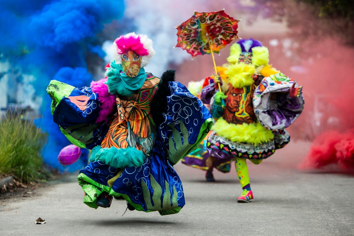 Members of a “bate-bola” or ball hitters group - men who dress up in exuberant, identical, hand-made costumes known as “fantasias” - run past during a Carnival tradition despite restrictions due to the new cornavirus pandemic, in Rio de Janeiro, Brazil, Saturday, Feb. 13, 2021. Rio’s city government officially suspended Carnival and warns it will have no tolerance for those who try to celebrate with open street parades or clandestine parties. (AP Photo/Bruna Prado).