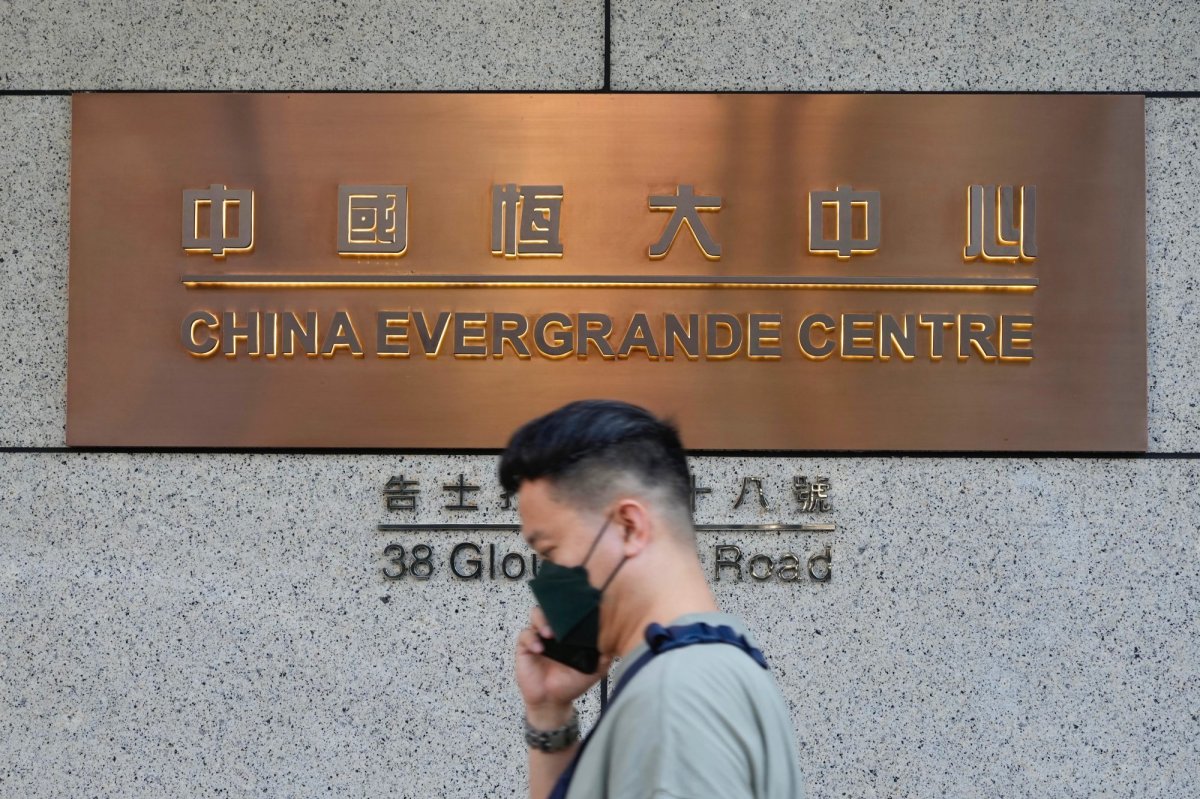 A man walks past the entrance of the headquarters of China Evergrande Group in Hong Kong Monday, Oct. 4, 2021. Shares in troubled real estate developer China Evergrande Group and its property management unit Evergrande Property Services were suspended from trading Monday in Hong Kong. (AP Photo/Vincent Yu).