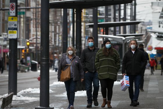 People wearing face masks walk on a street in Vancouver, British Columbia, Canada, on Dec. 27, 2021