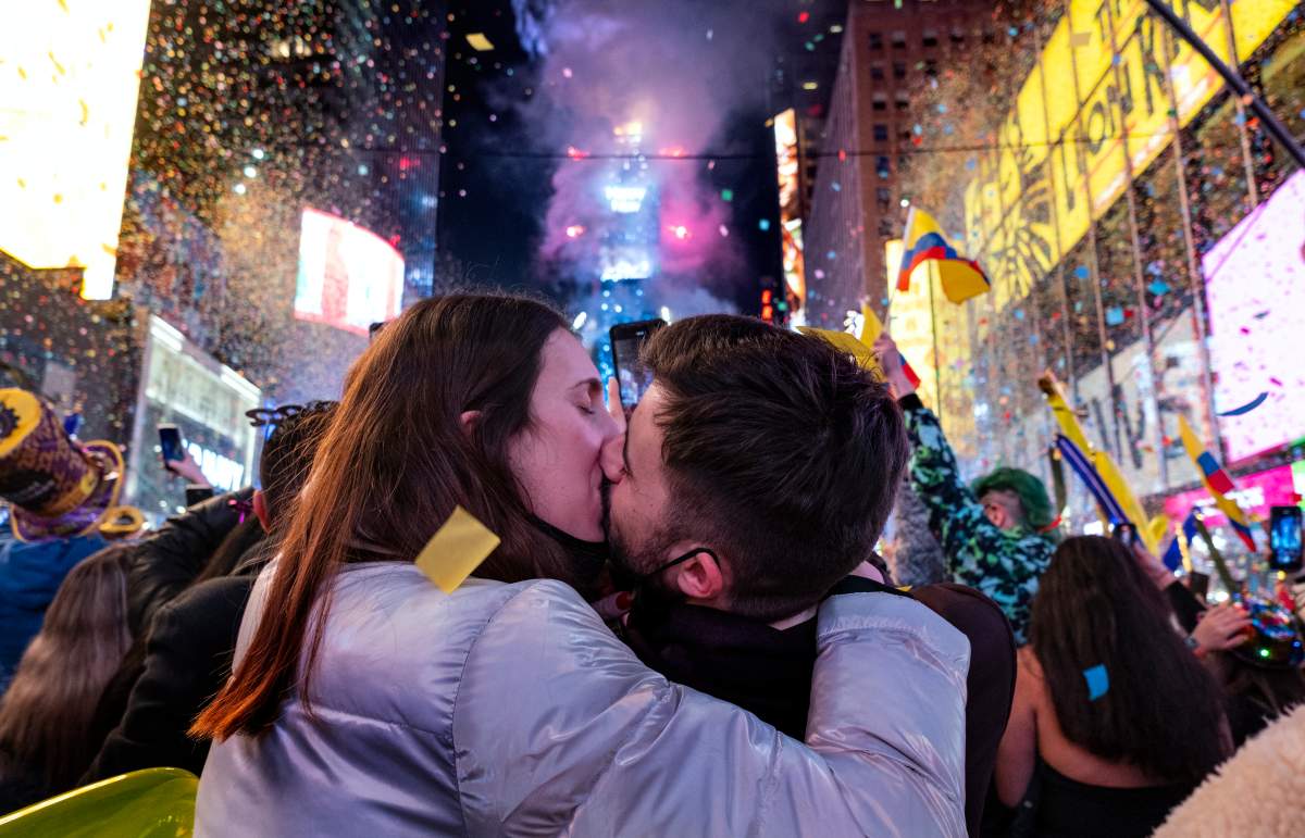 Irene Mayoral, left and Gerald Nuell, of Spain, kiss as they celebrate in Times Square in New York shortly after midnight Saturday, Jan. 1, 2022, as they attend New Year’s Eve celebrations. The couple became engaged Friday. (AP Photo/Craig Ruttle)