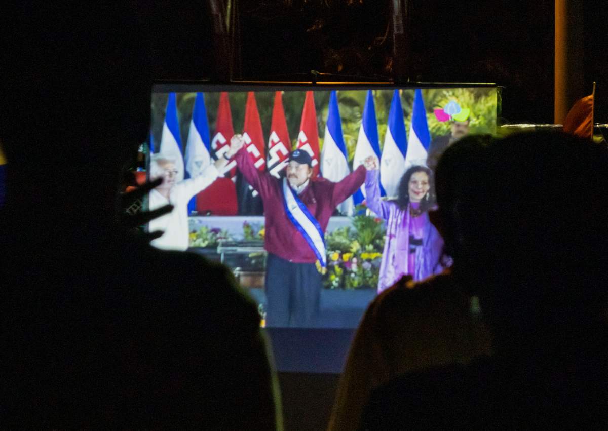 Neighbors watch the inauguration of President Daniel Ortega, on a giant screen at a park in the Julio Buitrago neighborhood of Managua, Nicaragua, Monday, January 10, 2022. Ortega was elected to a fourth consecutive term in Nov. 7 elections that were broadly criticized as a farce after seven likely challengers to Ortega were arrested and jailed in the months prior to the vote. (AP Photo/Andres Nunez).