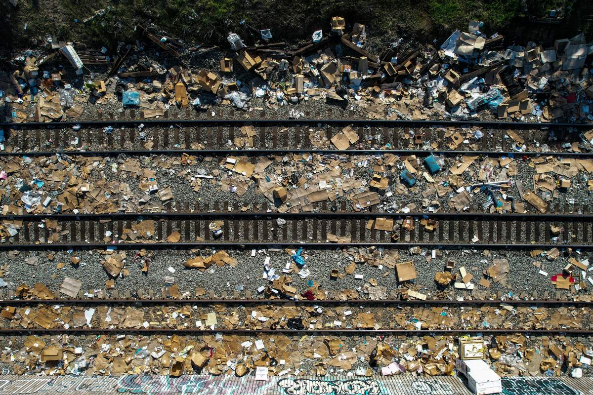 Shredded boxes and packages and debris are strewn along at a section of the Union Pacific train tracks in downtown Los Angeles Friday, Jan. 14, 2022. (AP Photo/Ringo H.W. Chiu)