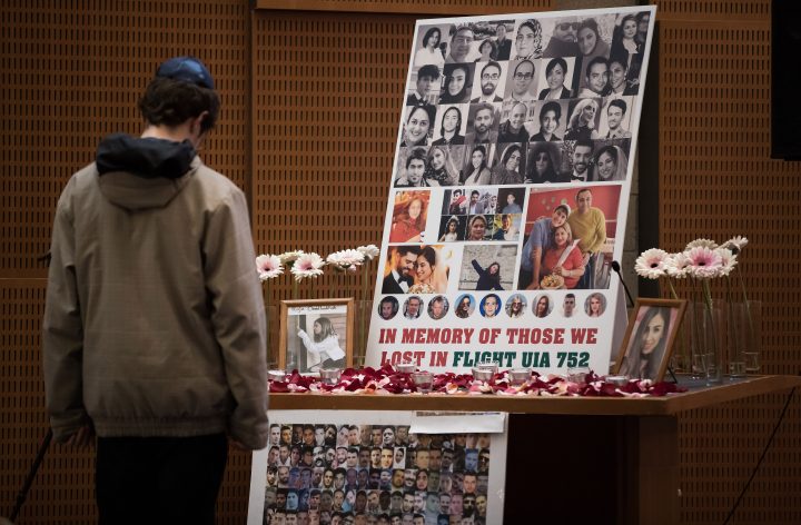 A man pauses to look at photographs of some of the people who died in the downing of Ukrainian Airlines Flight 752 in Iran, during a vigil for the victims of the flight at the Har El synagogue in West Vancouver on Sunday January 19, 2020. THE CANADIAN PRESS/Darryl Dyck.
