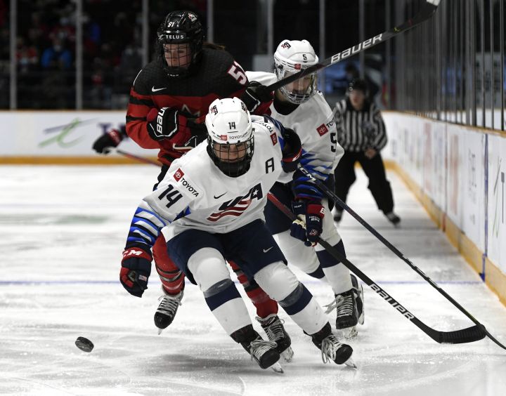 United States’ Brianna Decker (14) and Megan Kellar (5) keep Canada’s Victoria Bach (51) from the puck during second period Rivalry Series hockey action in Ottawa, on Tuesday, Nov. 23, 2021.