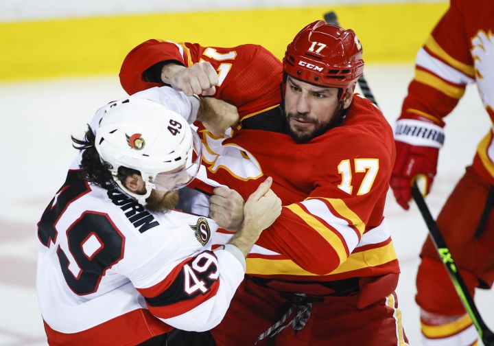 Ottawa Senators’ Scott Sabourin, left, fights with Calgary Flames’ Milan Lucic during second period NHL hockey action in Calgary, Thursday, Jan. 13, 2022.