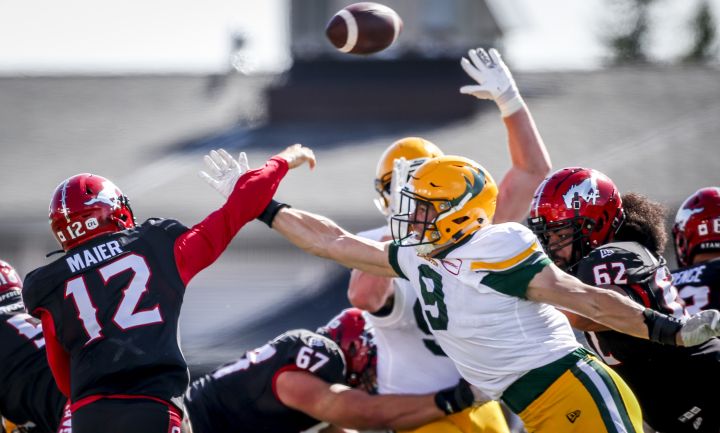 Edmonton Elks’ Mathieu Betts, right, tries to block as pass from Calgary Stampeders Jake Maier during first half CFL football action in Calgary, Monday, Sept. 6, 2021.