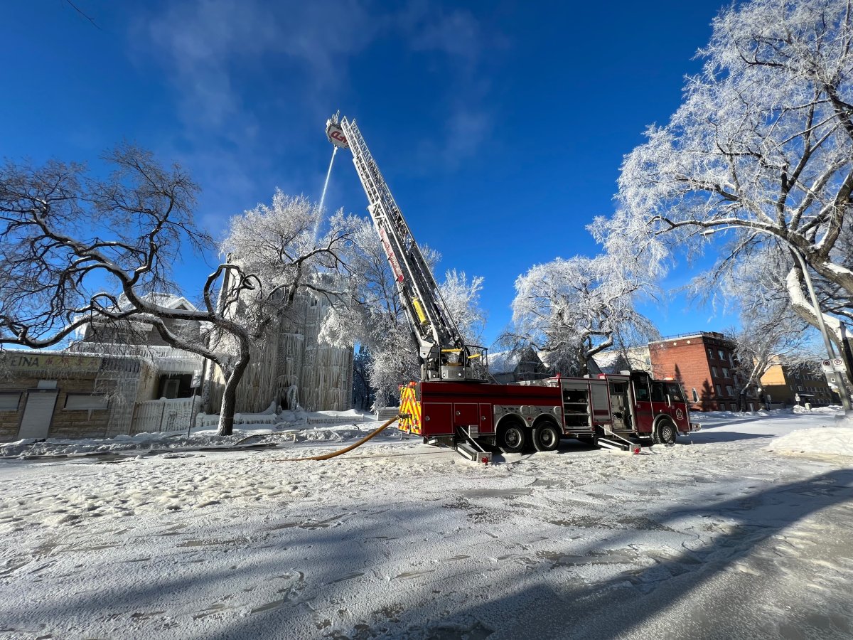 Fire fighters use an aerial hose to fight a fire at an apartment building on Sherbrook St. amid extreme cold and icy conditions Saturday afternoon.