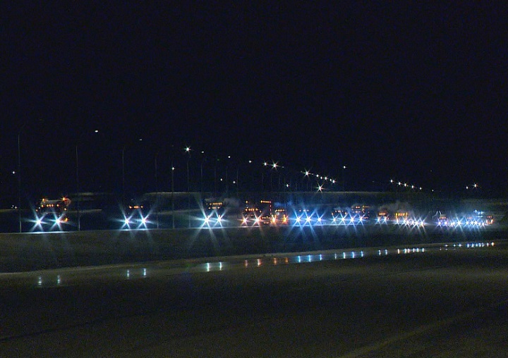 A long line of truck headlights shimmer in the night as they roll down the Regina Bypass on Monday.