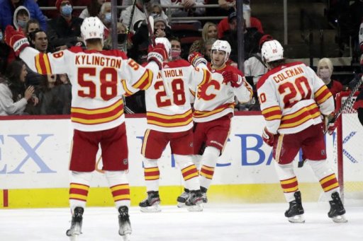 Calgary Flames left wing Matthew Tkachuk, second from right, celebrates his goal with defenceman Oliver Kylington (58), centre Elias Lindholm (28) and forward Blake Coleman (20) during the second period of an NHL hockey game against the Carolina Hurricanes, Friday, Jan. 7, 2022, in Raleigh, N.C.