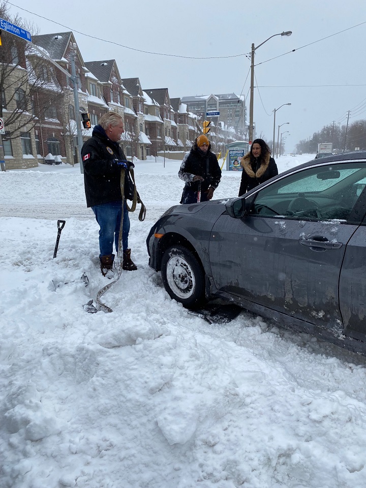 Premier Doug Ford helps to free a stuck vehicle following a major storm on Monday, Jan. 17, 2022.
