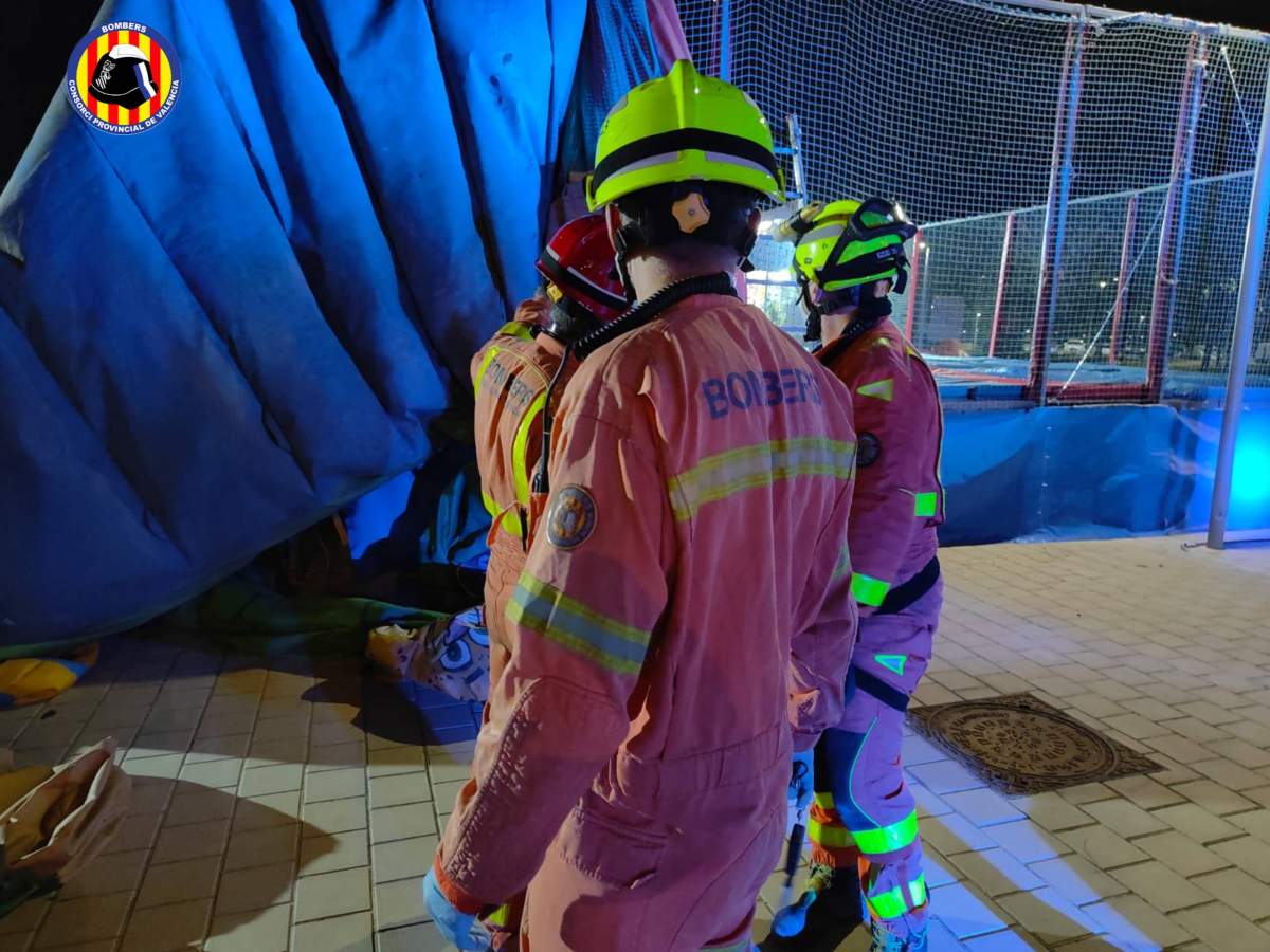 Spanish firefighters lift the bouncy castle to check for children trapped underneath.