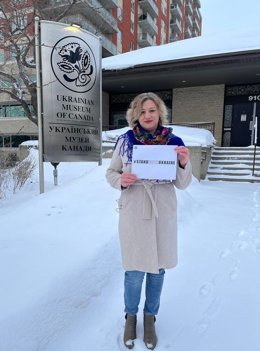 Iryna Matsiuk in front of the Ukrainian Museum of Canada in Saskatoon holding up the sign for #StandWithUkraine.