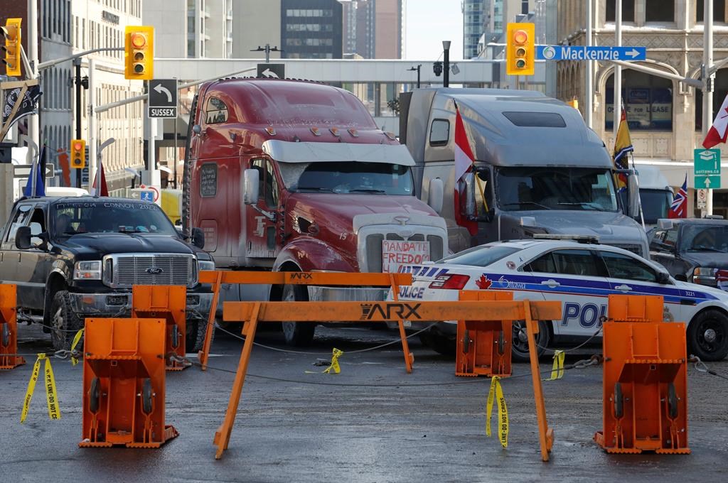 Trucks are blocked by police barricades as a rally against COVID-19 restrictions, which began as a cross-country convoy protesting a federal vaccine mandate for cross-border truckers continues in Ottawa on Tuesday, Feb. 1, 2022. Ottawa police have made two arrests following demonstration-related investigations, as the anti-vaccine mandate protest continues to keep the capital at a standstill. THE CANADIAN PRESS/Patrick Doyle.
