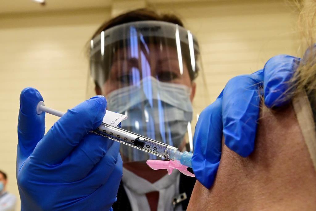 Tamara Dus, director of University Health Network Safety Services, administers a Pfizer-BioNTech COVID-19 vaccine in Toronto on Dec. 14, 2020.