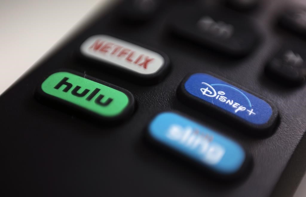Logos for streaming services Netflix, Hulu, Disney Plus and Sling TV pictured on a remote control