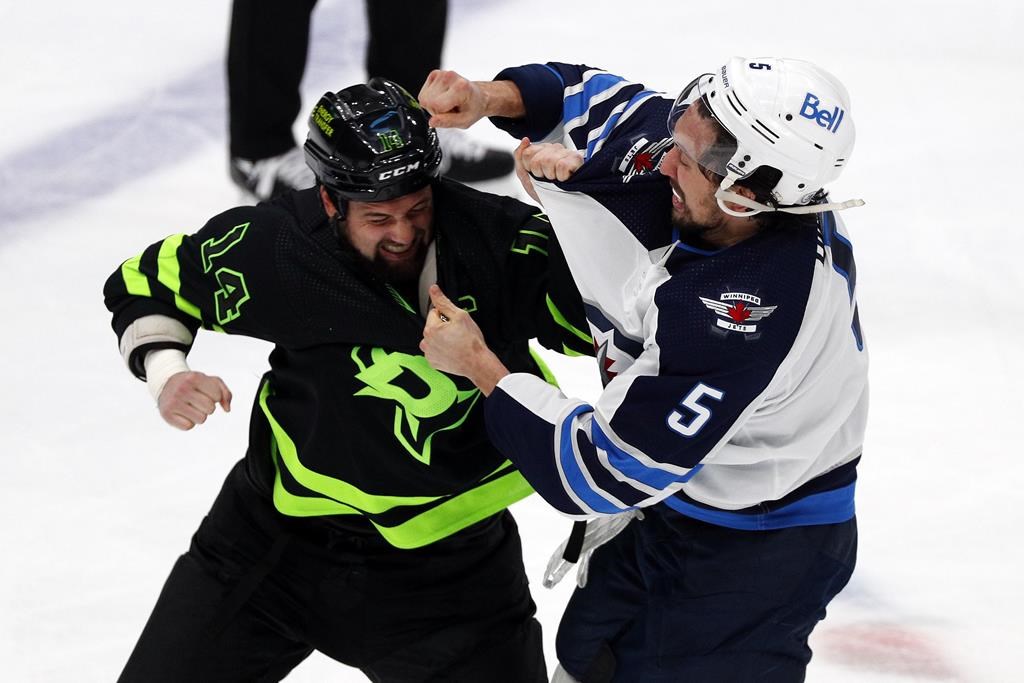 Dallas Stars left wing Jamie Benn (14) and Winnipeg Jets defenseman Brenden Dillon (5) fight in the second period of an NHL hockey game Friday, Feb 11, 2022, in Dallas.