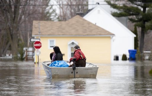 People use a boat to make their way along a flooded Rue Rene in Gatineau, Que., Saturday, April 27, 2019. A new study says flooding Canada experienced in the last decade reduced the final sale price of homes in several markets by 8.2 per cent. THE CANADIAN PRESS/Justin Tang