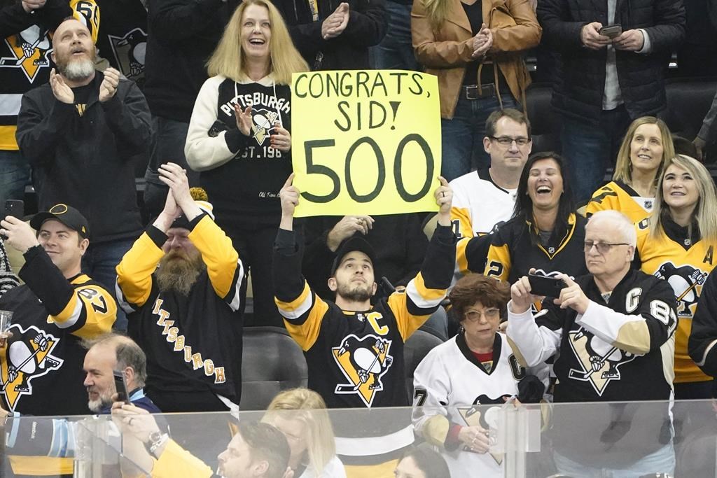 A fan holds up a sign recognizing the 500th goal after Pittsburgh Penguins’ Sidney Crosby, (87) scored his 500th NHL career goal against the Philadelphia Flyers, during the first period of an NHL hockey game, Tuesday, Feb. 15, 2022, in Pittsburgh. (AP Photo/Keith Srakocic)