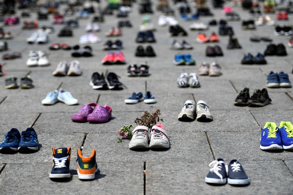 Dried flowers rest inside a pair of child's running shoes at a memorial for the 215 children whose remains were found at the grounds of the former Kamloops Indian Residential School at Tk’emlups te Secwépemc First Nation in Kamloops, B.C., on Parliament Hill in Ottawa on Friday, June 4, 2021. A British Columbia First Nation located off coast of northeastern Vancouver Island says it has started an investigation into the grounds of a former residential institution, following similar inquiries by a number of nations across the country. THE CANADIAN PRESS/Justin Tang.
