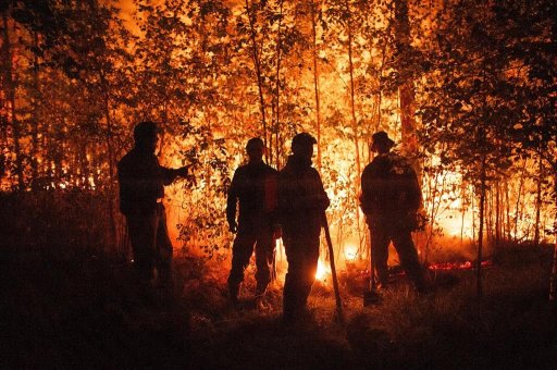 FILE -Firefighters work at the scene of forest fire near Kyuyorelyakh village at Gorny Ulus area, west of Yakutsk, in Russia Thursday, Aug. 5, 2021. A warming planet and land use changes mean more wildfires will scorch large parts of the globe in coming decades. That’s according to a UN report released Wednesday, Feb. 23, 2022 that says many governments are ill-prepared to address the problem. (AP Photo/Ivan Nikiforov, File)