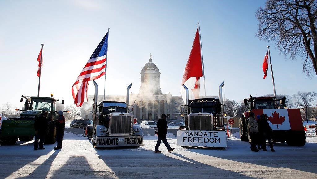 People rally against provincial and federal COVID-19 vaccine mandates outside the Manitoba legislature in Winnipeg, Friday, Feb. 4, 2022.