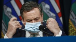 Alberta Premier Jason Kenney removes his mask as he gives a COVID-19 update in Calgary, Tuesday, Feb. 8, 2022.