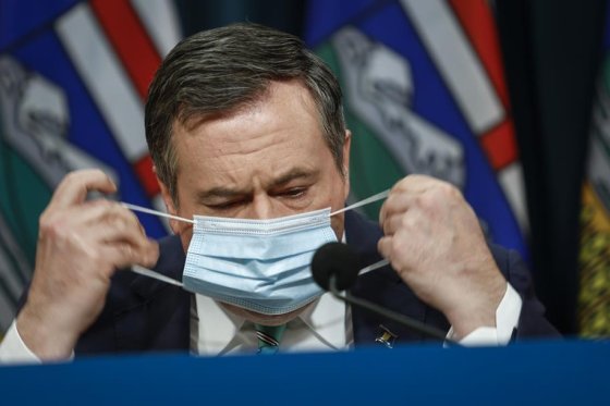 Alberta Premier Jason Kenney removes his mask as he gives a COVID-19 update in Calgary, Tuesday, Feb. 8, 2022.