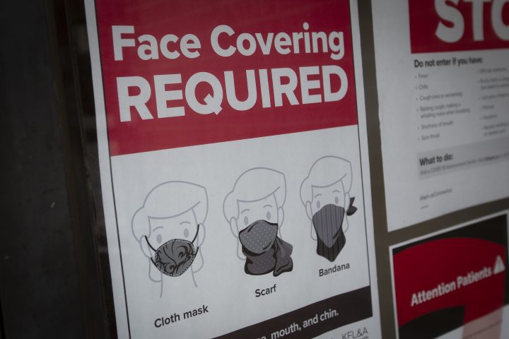 Face covering posters outside a store.
