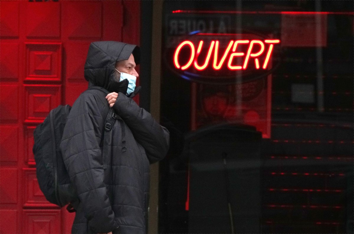 Man walks in front of a bar that was ordered closed by the government as the highly contagious Omicron variant rises exponentially in Montreal, Quebec, Monday, December 20, 2021. 