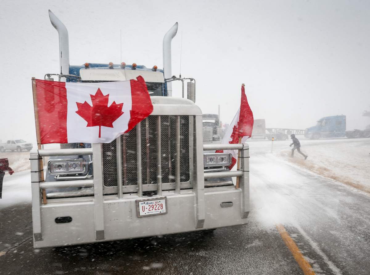 Anti-mandate demonstrators gather as a truck convoy blocks the highway the busy U.S. border crossing in Coutts, Alta., Monday, Jan. 31, 2022.