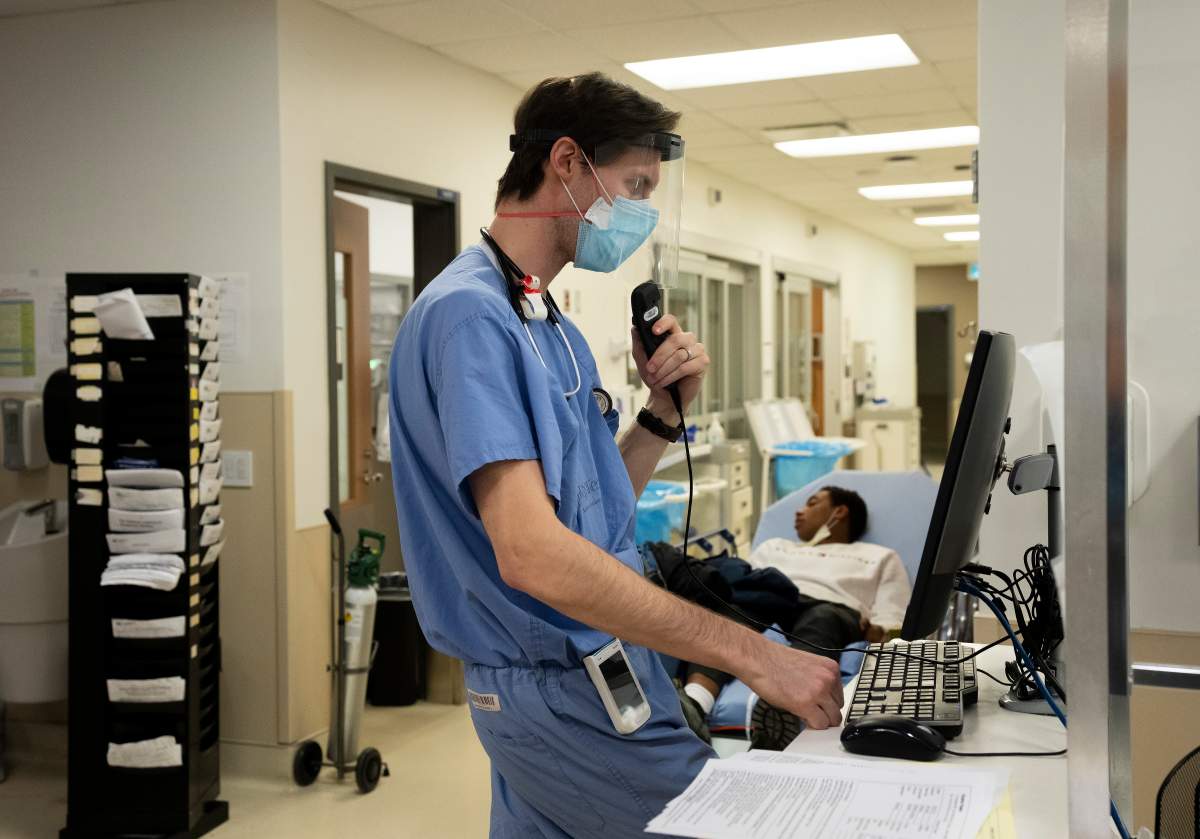 Emergency room physician Dr. Olivier Lavigueur works a computer while providing care for patients in the emergency room at the Humber River Hospital during the COVID-19 pandemic in Toronto on Tuesday, January 25, 2022.