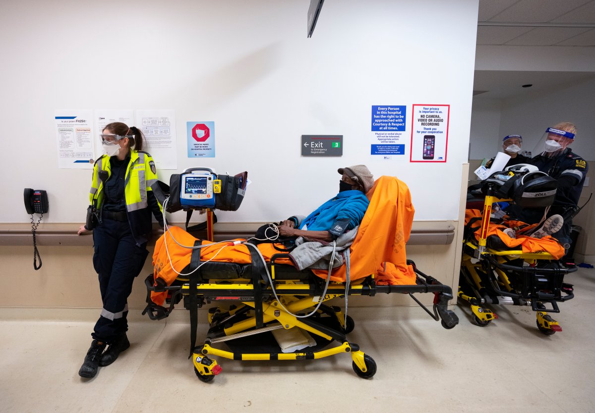 Paramedics transfer patients to the emergency room triage but have no choice but to leave them in the hallway due to an at capacity emergency room at the Humber River Hospital during the COVID-19 pandemic in Toronto on Tuesday, January 25, 2022. 