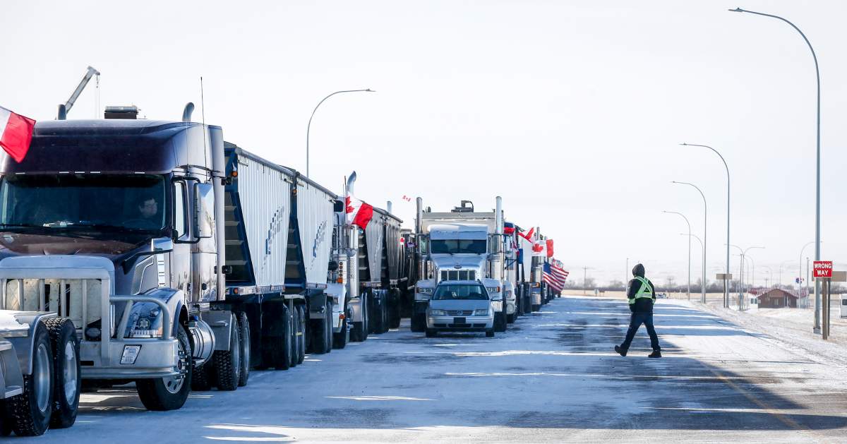 A driver crosses an open lane after a breakthrough to resolve the impasse at a protest blockade at the United States border in Coutts, Alta., Wednesday, Feb. 2, 2022. Trucks and other vehicles have begun clearing two lanes -- one going north and one going south.
