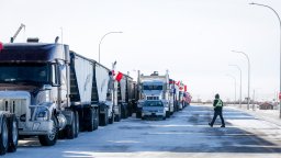 A driver crosses an open lane after a breakthrough to resolve the impasse at a protest blockade at the United States border in Coutts, Alta., Wednesday, Feb. 2, 2022. Trucks and other vehicles have begun clearing two lanes -- one going north and one going south.