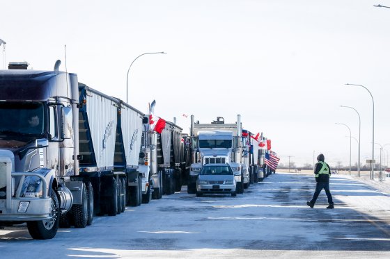 A driver crosses an open lane after a breakthrough to resolve the impasse at a protest blockade at the United States border in Coutts, Alta., Wednesday, Feb. 2, 2022. Trucks and other vehicles have begun clearing two lanes -- one going north and one going south.