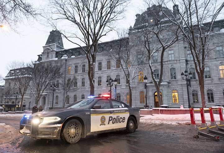 Sûrete du Quebec police officers sit in their car blocking the street in the back of the legislature, preparing for the arrival of demonstrators against measures taken by authorities to curb the spread of COVID-19, in Quebec City, Thursday, Feb. 3, 2022. A group of people coming from Sept-Iles, joined by people from Saguenay and the Beauce region are expected to gather until Saturday. The streets around the legislature have been blocked to stop trucks and motorists from blocking the surroundings as the Quebec Winter Carnival begins. 