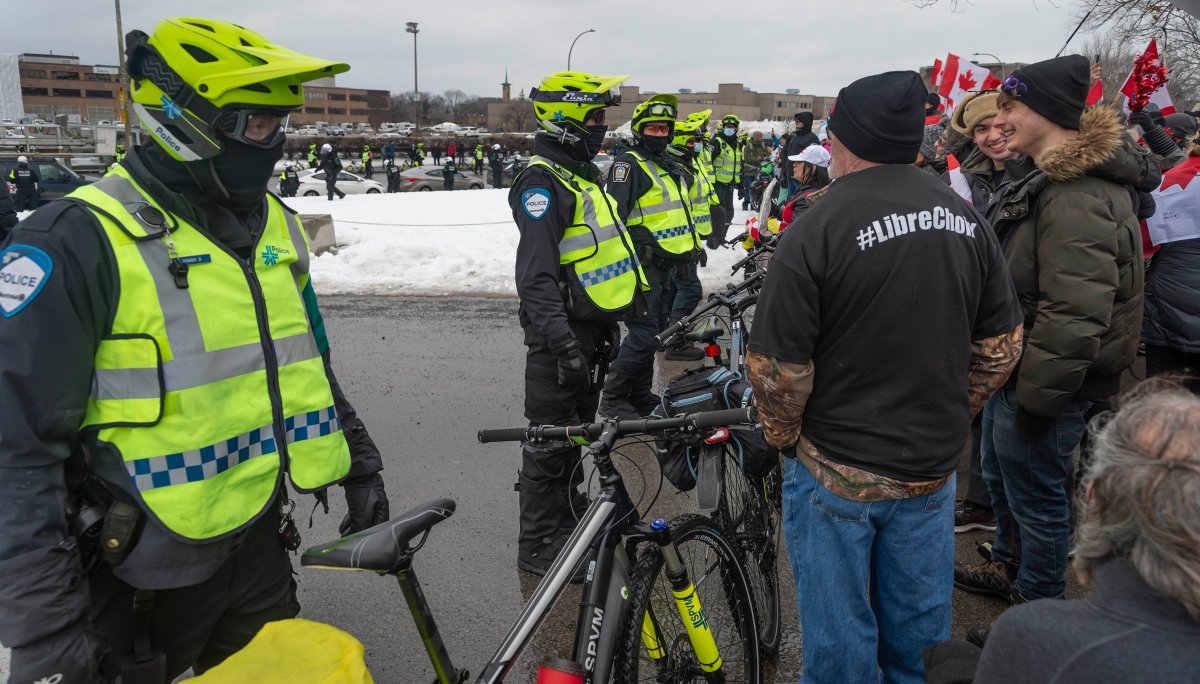 شرطة مونتريال تقف بالقرب من المتظاهرين ضد قيود COVID-19 في مسيرة في شوارع مونتريال يوم السبت 12 فبراير 2022.

