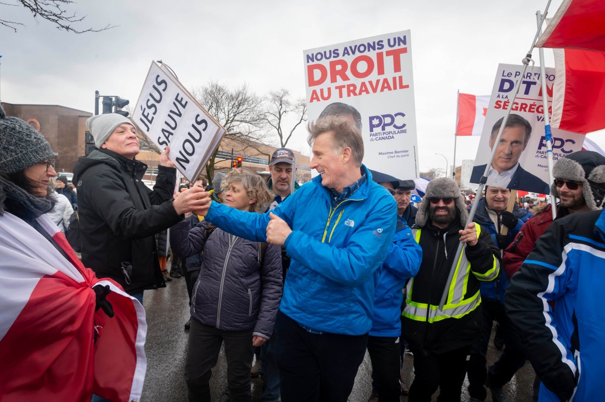 زعيم حزب الشعب الكندي ماكسيم بيرنييه يصافح رجلا أثناء مسيرة المتظاهرين ضد قيود كوفيد-19 في شوارع مونتريال يوم السبت 12 فبراير 2022