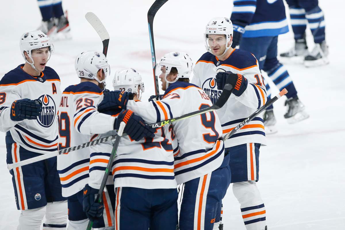 Edmonton Oilers’ Zach Hyman (18) celebrates his goal with teammates Ryan Nugent-Hopkins (93), Leon Draisaitl (29), Tyson Barrie (22), and Connor McDavid (97) during first period NHL action against the Winnipeg Jets, in Winnipeg, Saturday, Feb. 19, 2022.